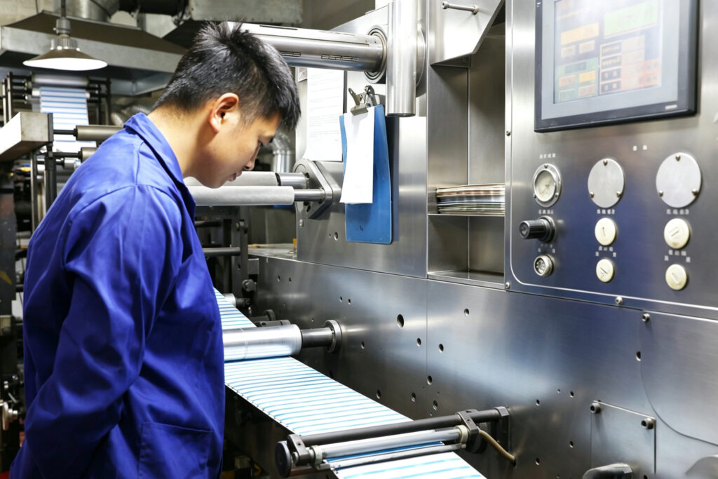 worker is operating roll to roll machine.